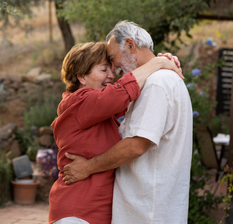 Happy adult couple hugging.